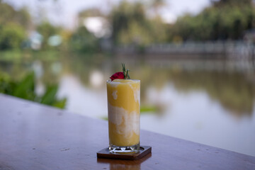 Mango and coconut smoothie on a table outdoors