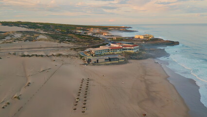 Aerial view beach complex at evening sunlight. Sunset sky over coastal nature 