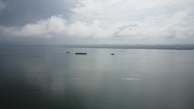 Aerial view of a tugboat towing an empty barge in the Kalimantan sea