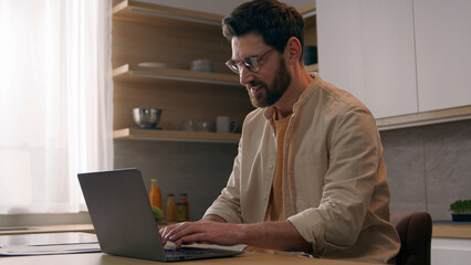 Business man in kitchen consider over issue journalist working on laptop search for inspiration and new ideas for article writer freelancer businessman thinking ponder typing writing with computer
