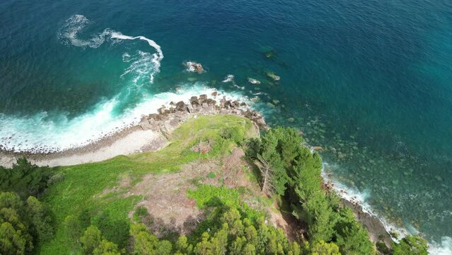 Aerial Video of the atlantic ocean in north spain with waves breaking and wonderful beautiful forest in the back. High quality 4k footage