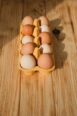 Chicken eggs of different brown and beige shades on a wooden background. Easter background. Top view