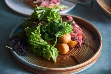 A dish of meat and potatoes. A festive table. A dish in a restaurant.