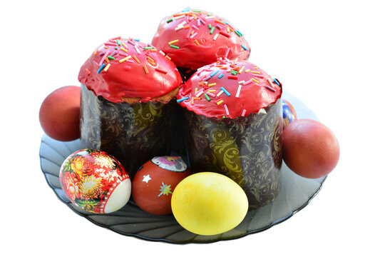 easter cakes with red glazing and easter eggs on plate isolated on white