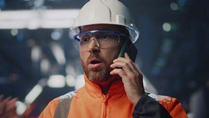 Worried factory specialist calling phone complaining on equipment close up.