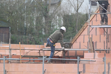 ouvrier maçon sur un chantier de construction d'une maison d'habitation - 753568703