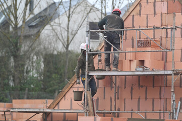 ouvrier maçon sur un chantier de construction d'une maison d'habitation - 753568705