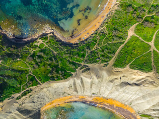 Ghain Tuffieha bay and beach. Spring, green countryside. Malta island, drone top view