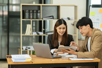 Asian business presents to explain the graph work on the whiteboard. Consulting, discussing, exchanging knowledge.