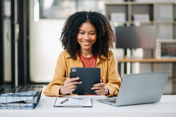 Confident business expert attractive smiling young woman holding digital tablet  on desk .