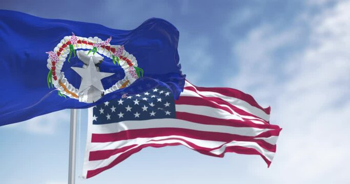 Flags of the Northern Mariana Islands and the United States of America waving on a clear day