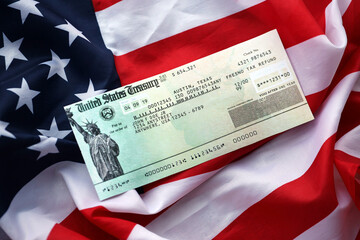 United States Treasury Refund check on waving American Flag close up.