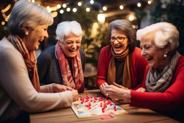 senior women friends at a home party gathering playing board game, smiling and laughing and having fun