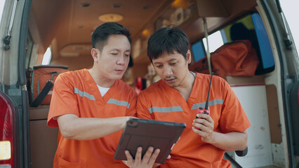 Rescue personnel preliminary talking by portable radio and working on tablet before being taken injured to the hospital. EMS Paramedic. First aid procedure. Emergency Medical First aid © M Stocker