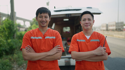 Portrait of two paramedics man. Two asian paramedic man in uniform standing with arms crossed rear...
