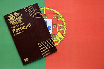 Red Portugal passport of European Union on national flag background close up. Tourism and...