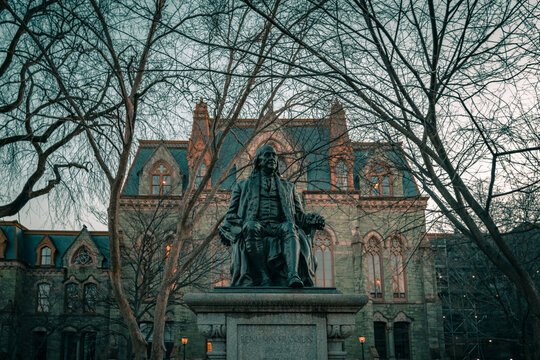 Historic College Hall and Benjamin Franklin Statue in the evening