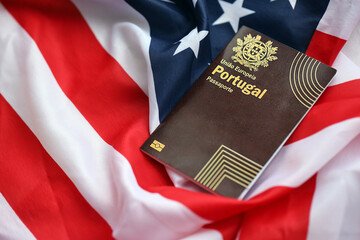 Red Portugal passport of European Union on United States national flag background close up. Tourism...