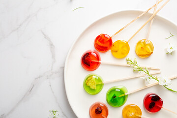 Sugar fruits lollypop candy on light surface top view