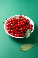 Close up ripe sour cherry in bowl organic fruits green surface