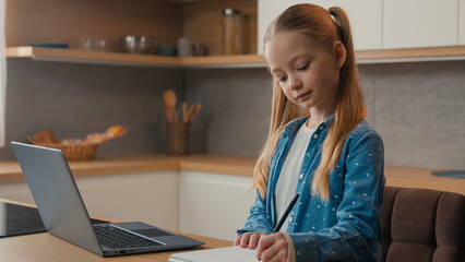 Caucasian kid girl school pupil studying online from home watching laptop web class lesson teacher...