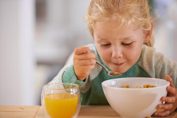 Home, eating and cereal with girl or child, happy morning and nutrition with table. Breakfast, glass or orange juice for vitamins, fibre for toddler and healthy development of growing kid in house