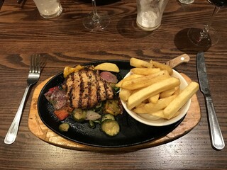 Grilled chicken breast with a plate of fries & vegetables