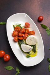 Caprese salad with mozzarella cheese, cherry tomatoes and basil