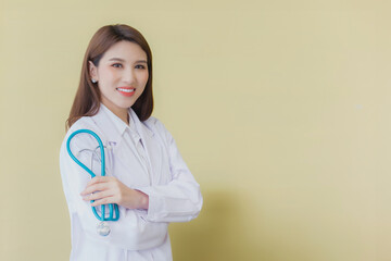 Young asian woman doctor standing with arms crossed confidently in hospital wearing medical uniform and stethoscope in the theme of health check while isolated white background.