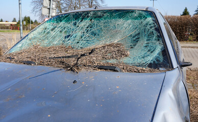 Broken car windshield. Old and abandoned car on the parking. Smashed window.