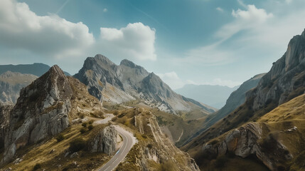 a breathtaking vista of rugged mountains from the perspective of a winding road ascending through the peaks, showcasing the thrill of conquering nature's obstacles - obrazy, fototapety, plakaty