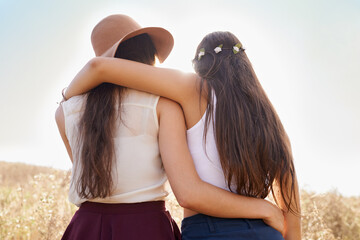Friends, hug and walking on path in nature on holiday or journey on vacation in summer for...