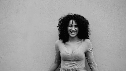 Charismatic African American young woman laughing and smiling in black and white. Happy joyful 20s...