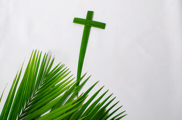 Palm cross and palm leaves, white background, and copy space. Palm Sunday and easter day concept.