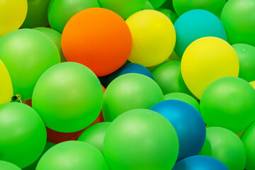 Green yellow orange blue rubber inflatable balloons close up texture