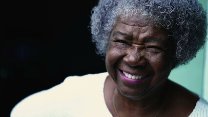 One joyful elderly black woman laughing and smiling. Gray hair African American senior lady...