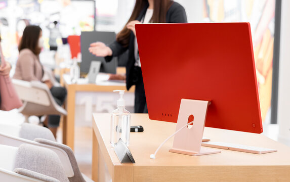Neat, clean, paperless customer service work desk with modern desktop computer in red. Customer service serving customer as bokeh background.