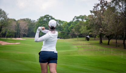 Professional woman golfer teeing golf in golf tournament competition at golf course for winner	
