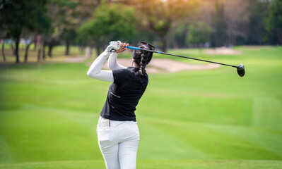 Professional woman golfer teeing golf in golf tournament competition at golf course for winner	
