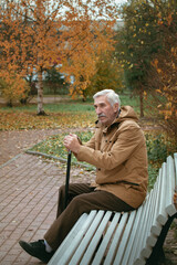 Fototapeta premium grandfather sitting on a park bench alone