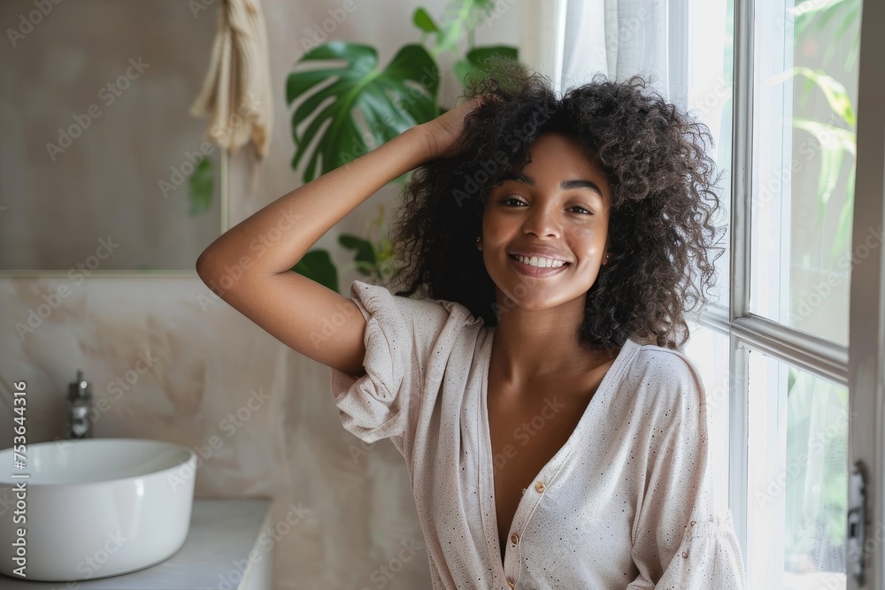 Wall mural A cheerful young woman with curly hair stands in a well-lit bathroom, exuding a carefree vibe