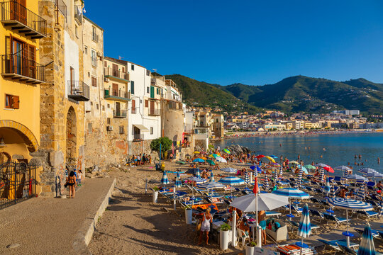 Tourists on beach, Cefalu, mountains in background, Province of Palermo, Sicily, Italy