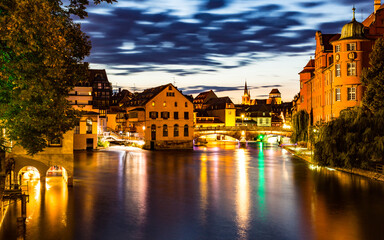 Beleuchtete Gebäude bei Nacht an einem Fluss