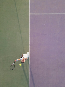 Tennis player serving from high angle view on court