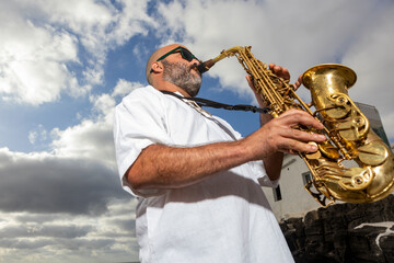 Saxophonist Performs Outdoors Against Cloudy Sky