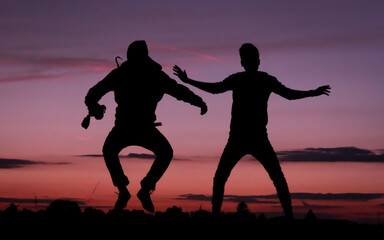 Silhouetten von Personen vor einem wunderschön bunten Himmel bei Abenddämmerung