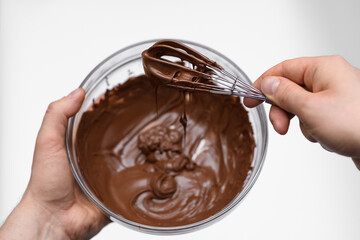Mieszanie roztopionej czekolady mlecznej w misce na białym tle  - obrazy, fototapety, plakaty
