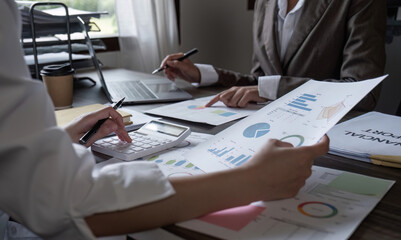 Close-up, A team of accountants and businesswomen sit and work on numbers and graphs. On the laptop on the table in the office
