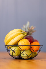 Fruit basket on the table in bright kitchen with blurred background for decoration
