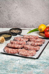 Raw hamburger Patty. Butcher products. Raw hamburger patties with gelatin on a stone background